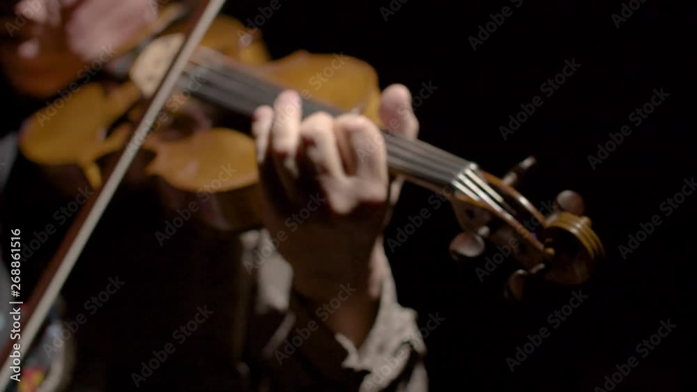 man playing the viola in slow motion with black background man playing the viola in slow motion with black background