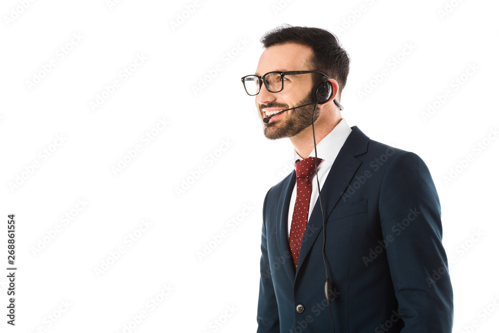 handsome call center operator in headset smiling and looking away isolated on white