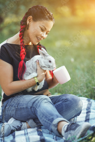 Pretty Girl With Hair Braiding Huggs a Rabbit on Beautiful Summer Nature photo