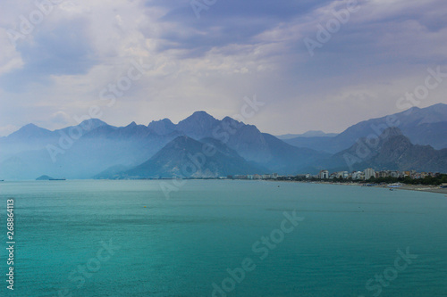 Beach with rocks, mountains and bright clear turquoise water. Turkish paradise. Antalya, Turkey