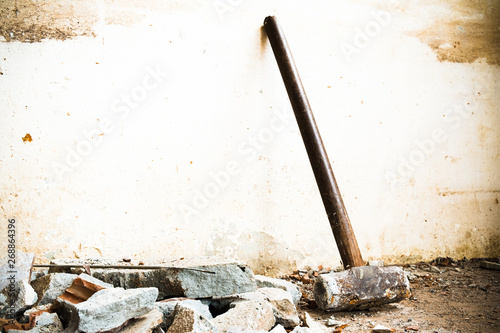 A hammer used to demolish the concrete tile floor and wall of the house before renovation. It heavy and very hard because it made from metal.