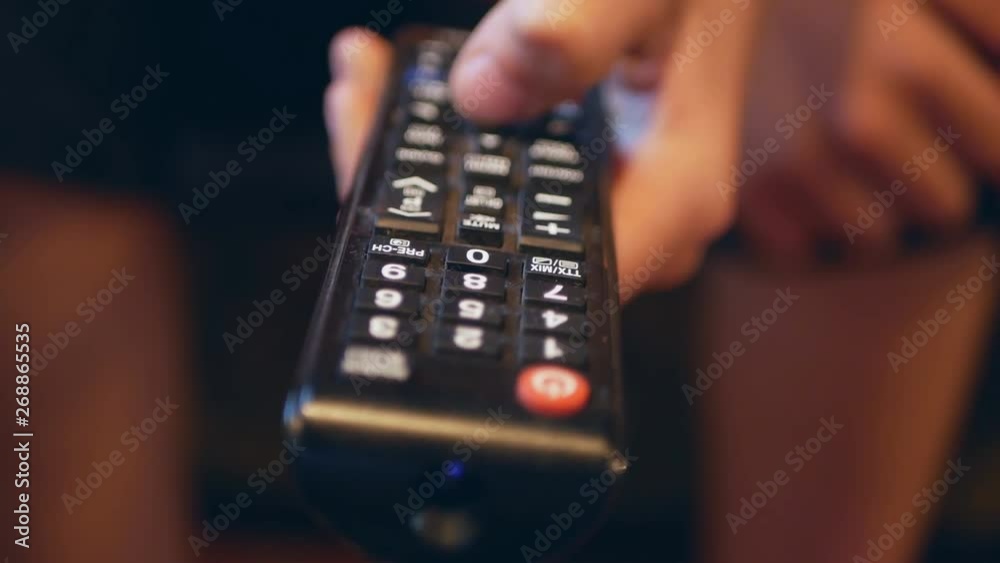 TV remote control close-up. Change channels on the TV remote. Hand using tv remote control TV remote control close-up. Change channels on the TV remote. Hand using tv remote control