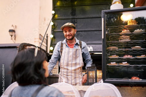 Customer selecting pastry at a food truck