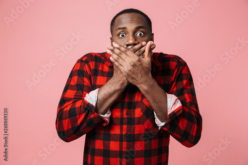 Portrait of a shocked african man wearing plaid shirt