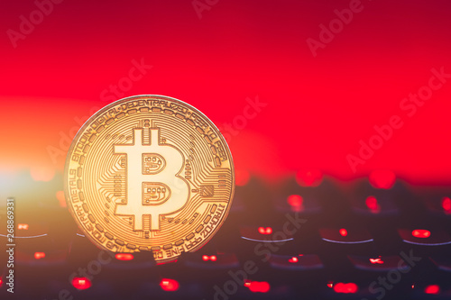 Bitcoin on compuer keyboard in background, symbol of electronic virtual money and mining cryptocurrency concept. Coin crypto currency bitcoin lies on the keyboard. Bitcoin on keyboard. photo