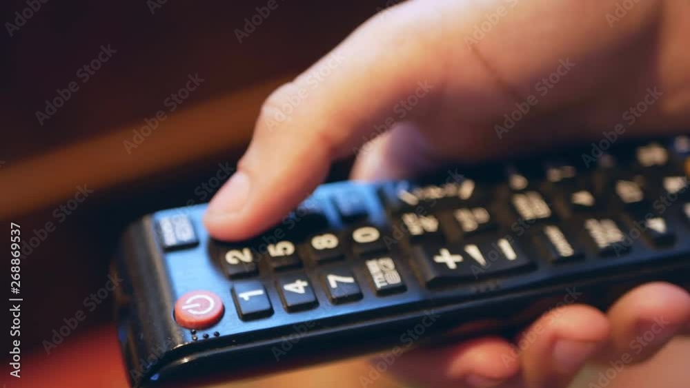 TV remote control close-up. Change channels on the TV remote. Hand using tv remote control TV remote control close-up. Change channels on the TV remote. Hand using tv remote control