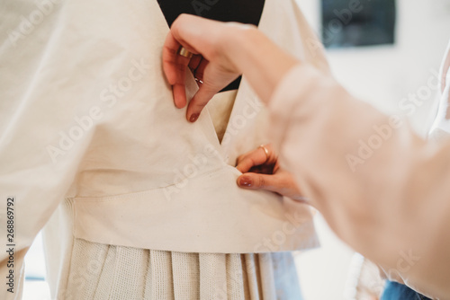 Young female fashion designer alter their garments on the mannequin