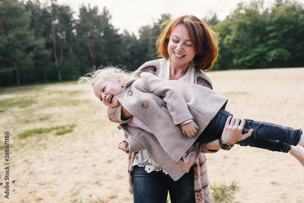 Mother and daughter playing __ the forest glade Mother and daughter playing __ the forest glade