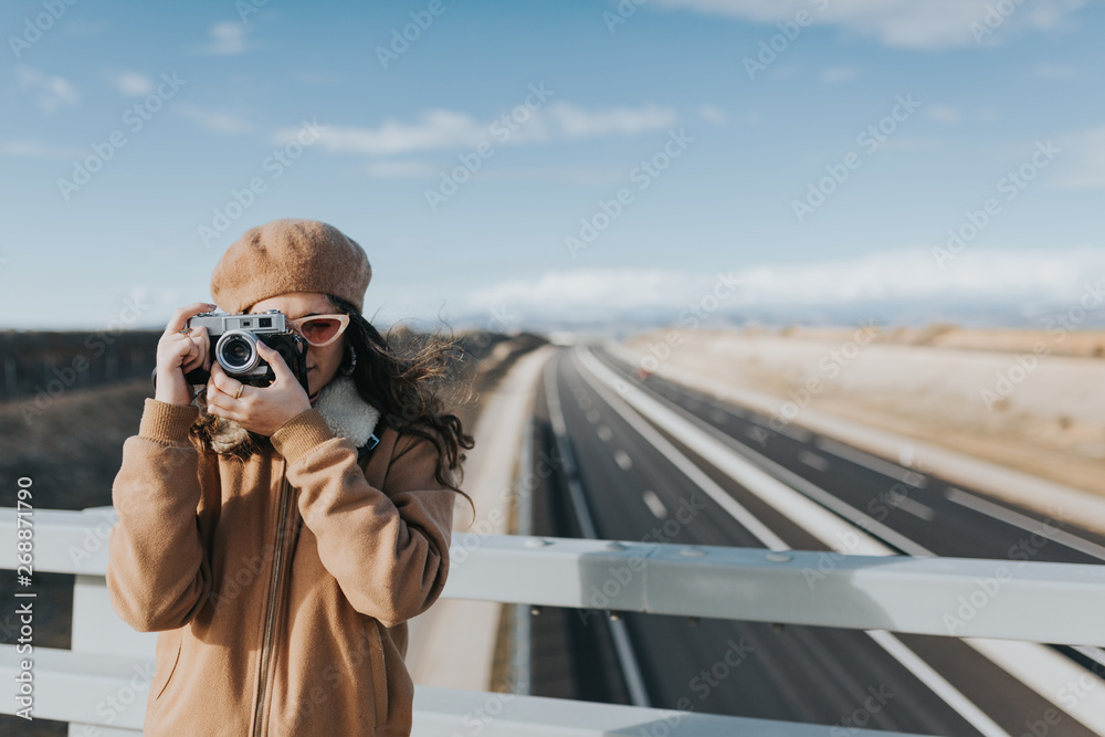 © Javier Pardina/Stocksy - photographer woman with vintage style, walking and taking photos. © Javier Pardina/Stocksy - photographer woman with vintage style, walking and taking photos.