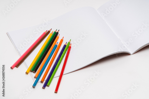 drawing album and color pencils on a white background. back to school