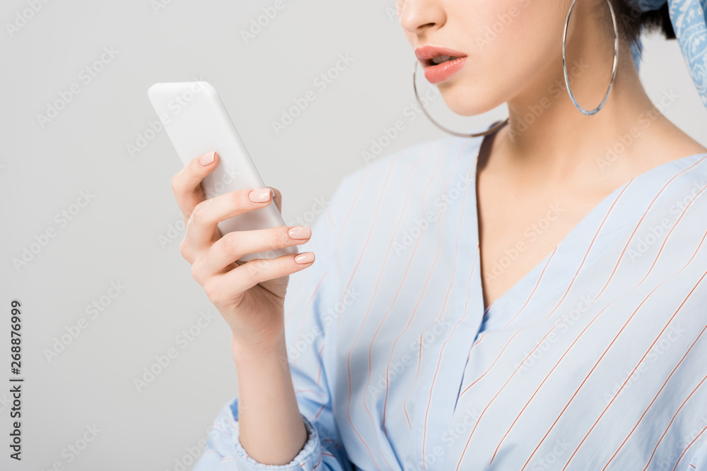 Cropped view of stylish girl using smartphone isolated on grey