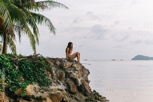 Woman sitting on rocks at the beach