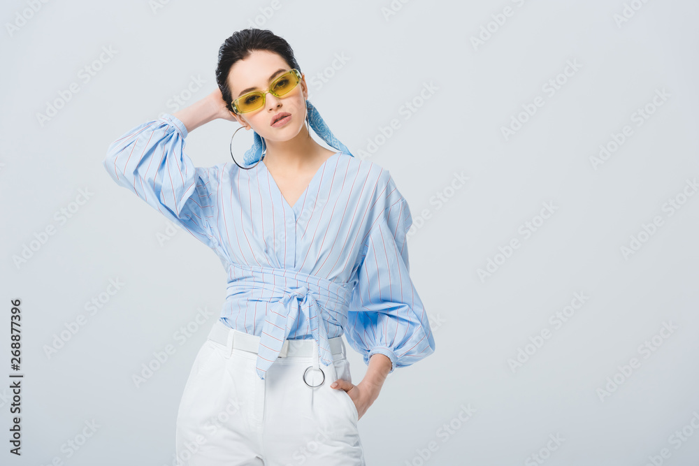 beautiful stylish girl in sunglasses posing isolated on grey with copy space