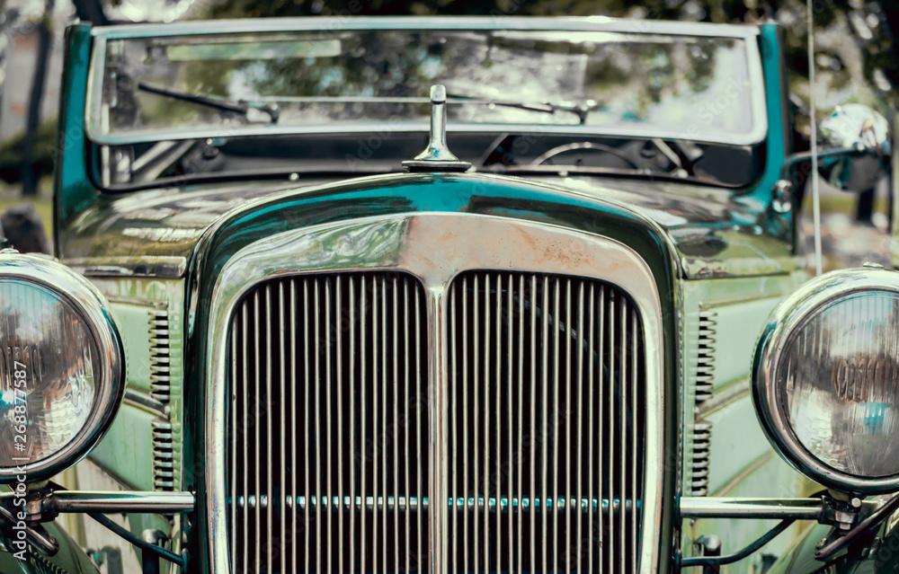 headlights and radiator of green old retro car close up