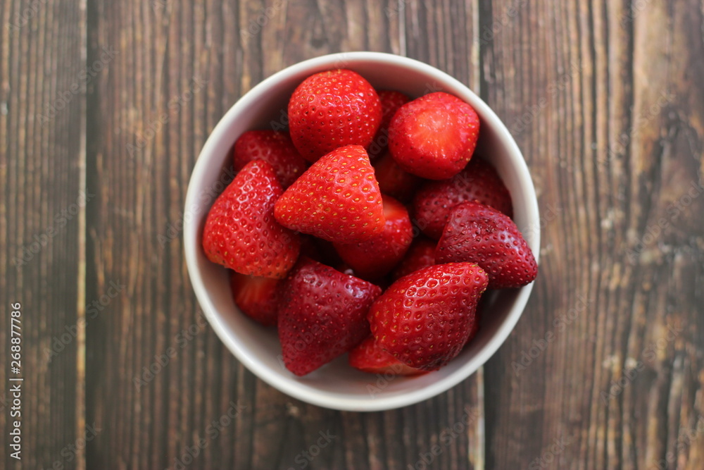 top view strawberries in bowl on wood background top view strawberries in bowl on wood background
