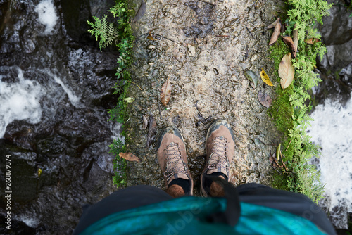 View from above of body parts of adventurer trekking through jungle.