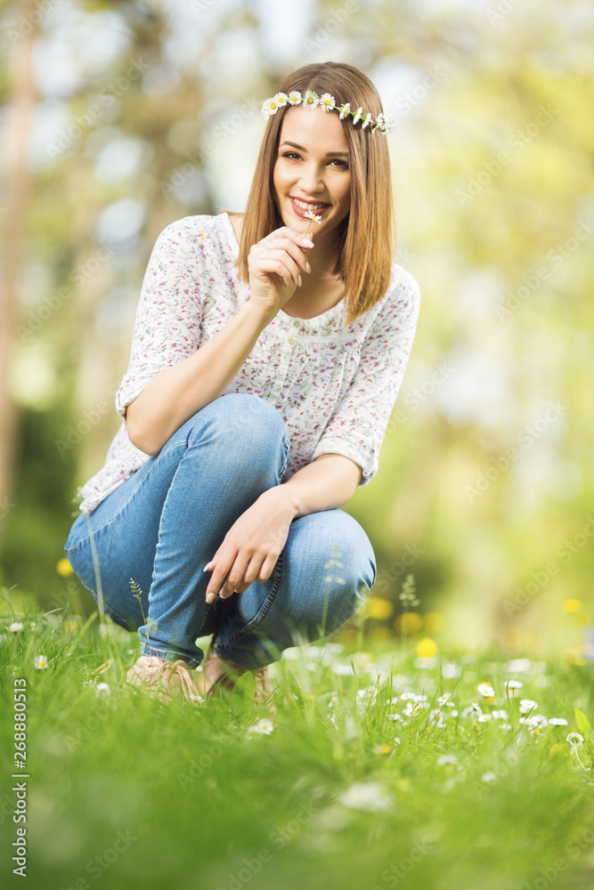 Beautiful blonde woman making daisy crown Beautiful blonde woman making daisy crown