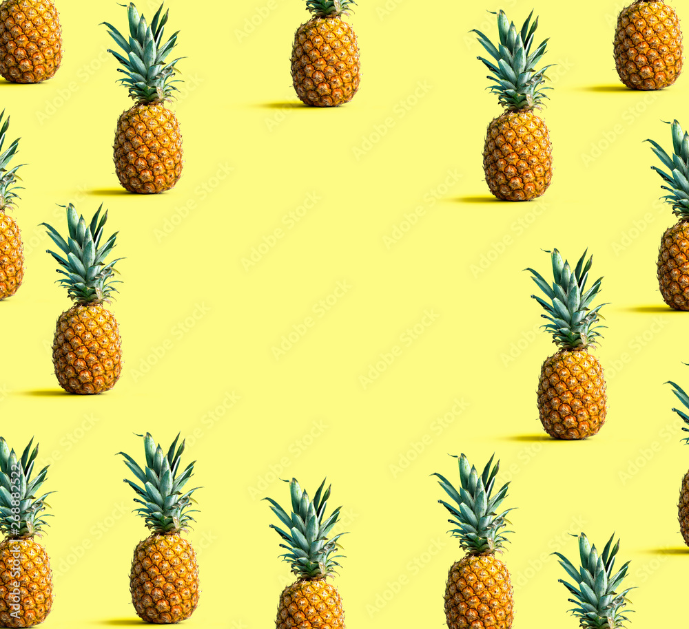 Round frame of pineapples on a solid color background