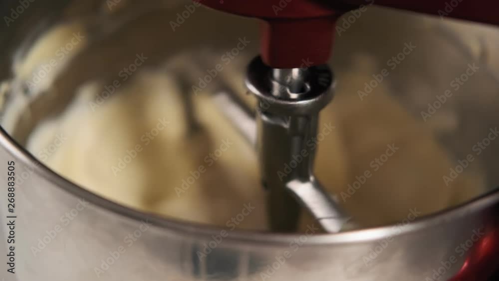 Step by step. Electronic mixer blending ingredients into cream. Mixing cream for cake in red electric kitchen mixer. Step by step. Electronic mixer blending ingredients into cream. Mixing cream for cake in red electric kitchen mixer.