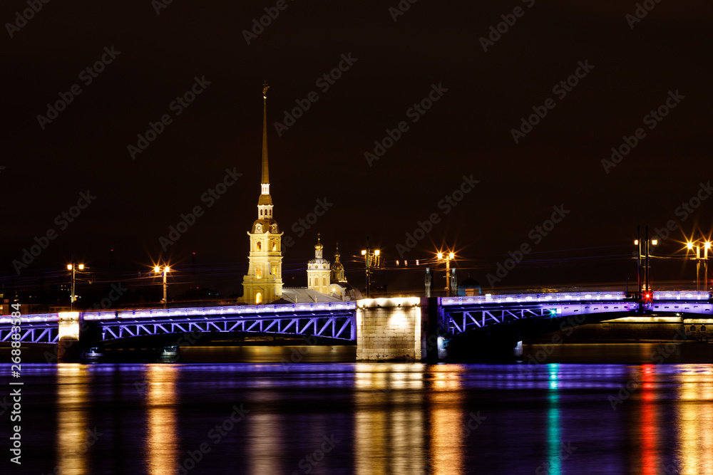 Long exposure photography of the Palace Bridge in Saint Petersburg at night with illuminated Peter and Paul Fortress in the background (St. Petersburg, Russia, Europe) Long exposure photography of the Palace Bridge in Saint Petersburg at night with illuminated Peter and Paul Fortress in the background (St. Petersburg, Russia, Europe)