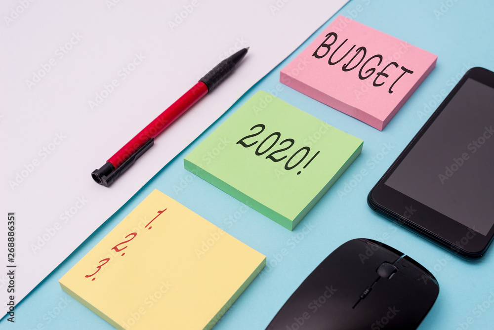 Word writing text Budget 2020. Business photo showcasing estimate of income and expenditure for next or current year Note papers and stationary plus gadgets placed sideways above backdrop
