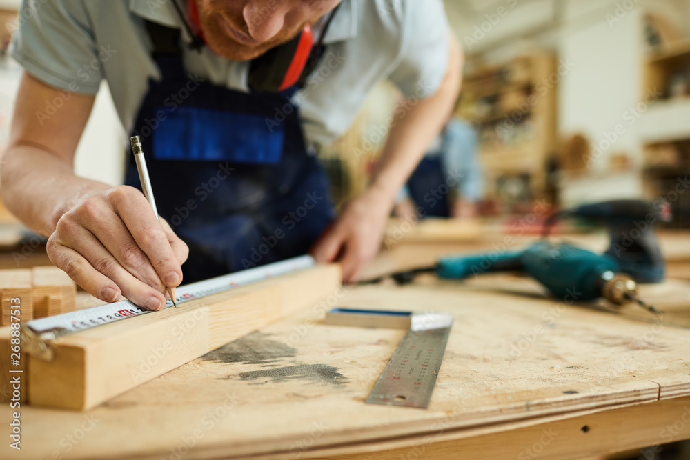 Mid section portrait of unrecognizable carpenter working with wood standing at table in workshop, copy space Mid section portrait of unrecognizable carpenter working with wood standing at table in workshop, copy space