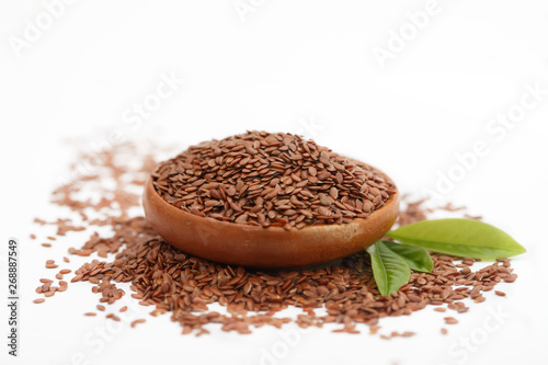 Brown flax seed or linseed in small bowl on white background. Healthy food.