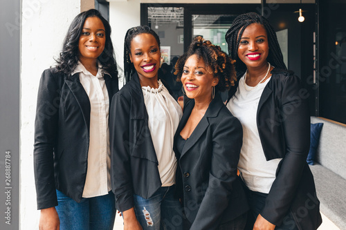 Portrait of four smiling business partners seated
