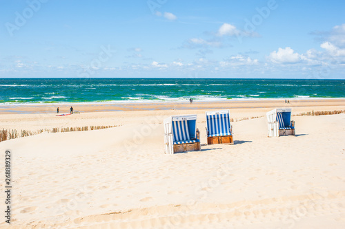 Beach in Westerland with the typical german roofed beach chairs or "Strandkorb" and white sand, Sylt island, North Sea, Germany