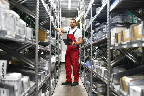 Quadro em tela friendly worker in a warehouse and trade for car spare parts of a car repair sho