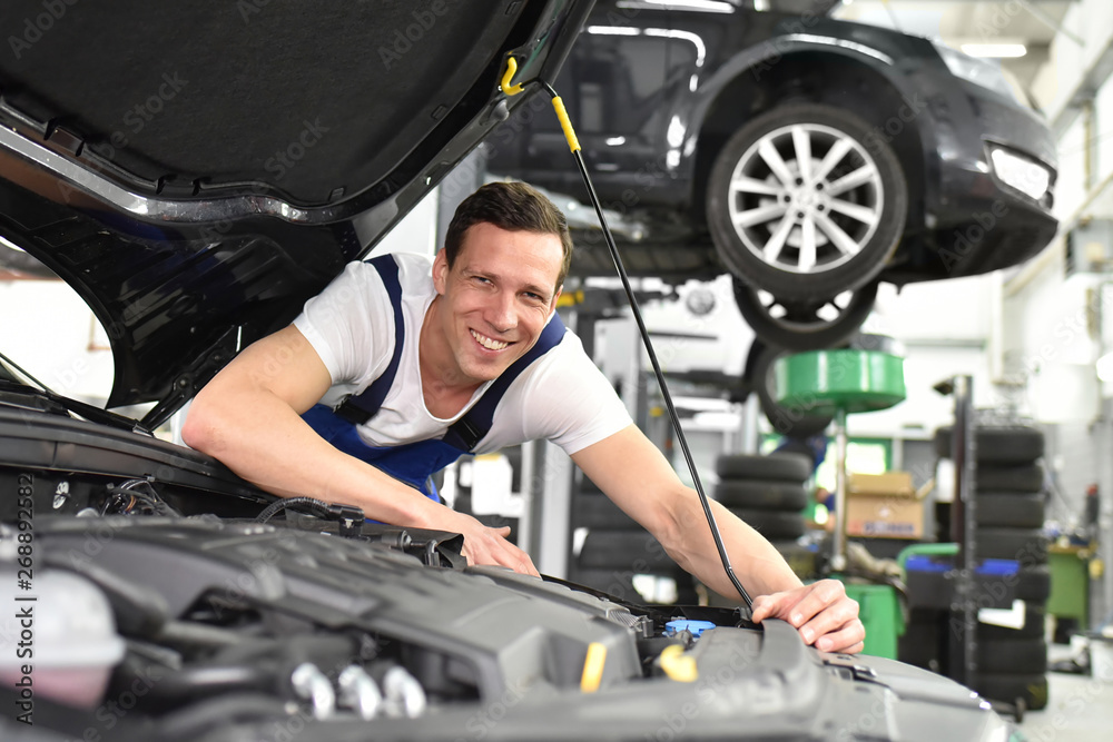 Portrait fröhlicher Automechaniker in der Werkstatt - Beruf