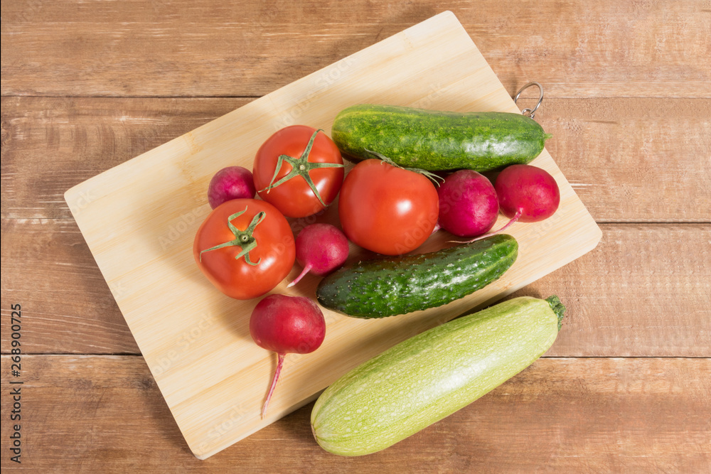 Tomatoes, pills, radishes and zucchini on a wooden background. Tomatoes, pills, radishes and zucchini on a wooden background.