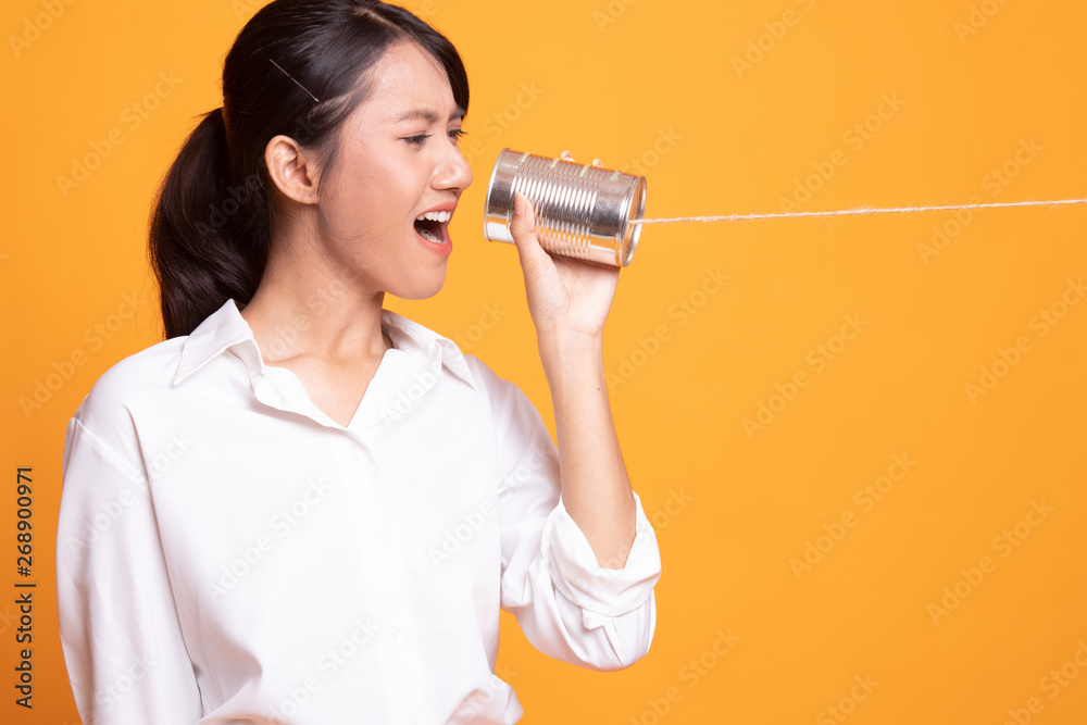 Young Asian woman shout with tin can phone. Young Asian woman shout with tin can phone.