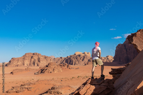 A tourist standing by the look out of a panoramic view of the desert in Wadi Rum, Jordan, Middle East.
