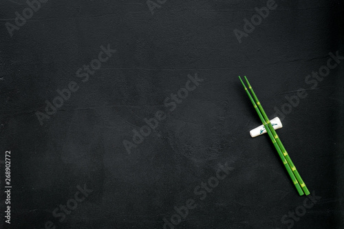 bamboo sticks for sushi and maki on black background top view mockup