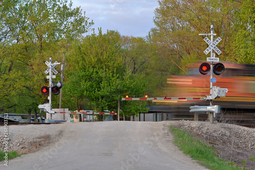 Carta da parati Freight train blurred  in motion at crossing gate