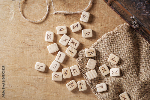 Handmade scandinavian wooden runes on a wooden vintage background. Concept of fortune telling and prediction of the future. photo