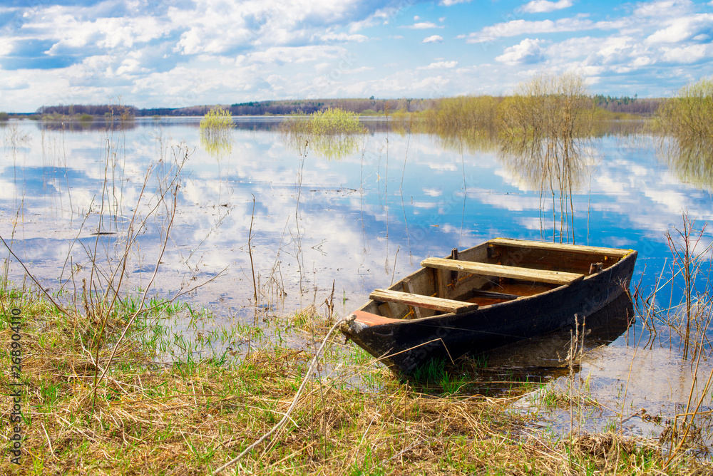 Old wooden boat near the river. Spring flood Old wooden boat near the river. Spring flood