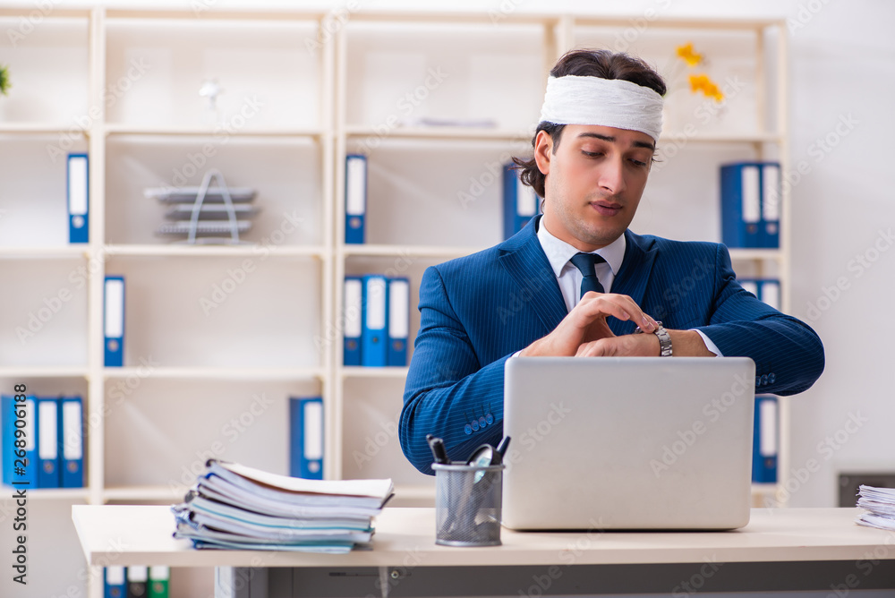 Head injured male employee working in the office 