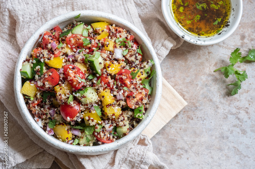 Fresh quinoa tabbouleh salad with tomatoes, peppers and cucumbers photo