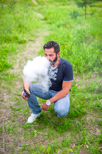 Modern smoker smoking an electronic smoke device. Vape. photo