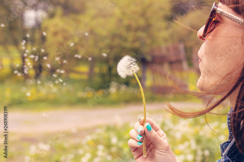 Valokuvatapetti Pretty girl blowing dandelion in summer park