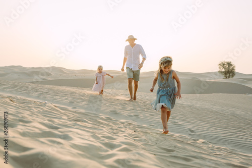 Father with two daughters in the desert in Dubai