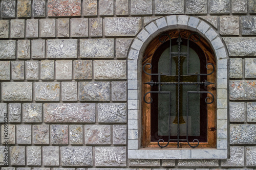 a window on the Orthodox church with a stone wall