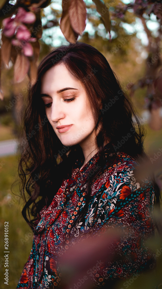 Beautiful young woman by branches with burgundy and green leaves. Romantic fashion look. Dreamy girl Beautiful young woman by branches with burgundy and green leaves. Romantic fashion look. Dreamy girl