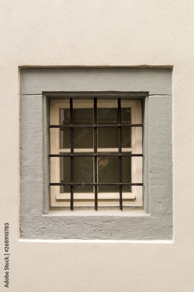 Window with iron grating and white wall