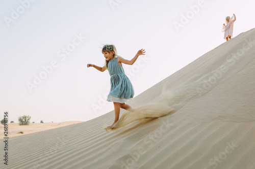 Two little sisters running in the desert and having fun