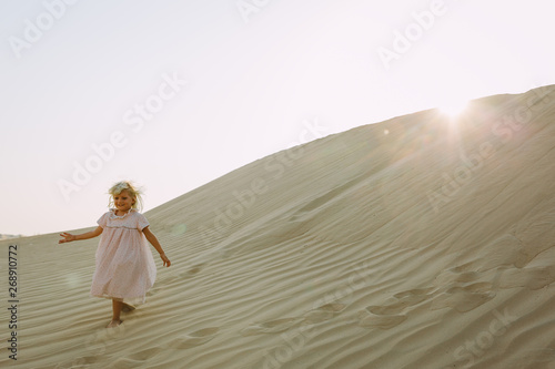 Little girl walking on a dune in the desert