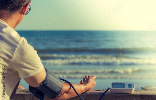 Hypertensive patient performing an automatic blood pressure test on the beach