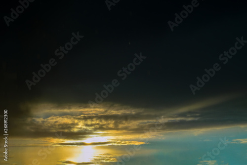 The sky with dark clouds illuminated by the setting sun